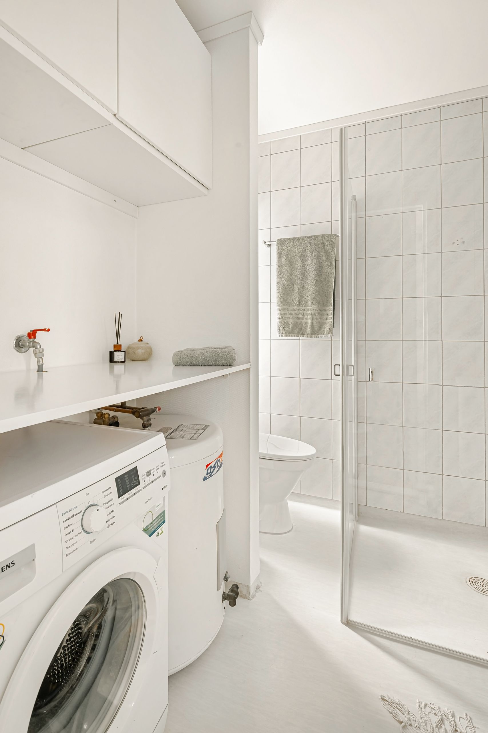 Baño pequeño con soluciones de almacenaje y lavadora integrada
