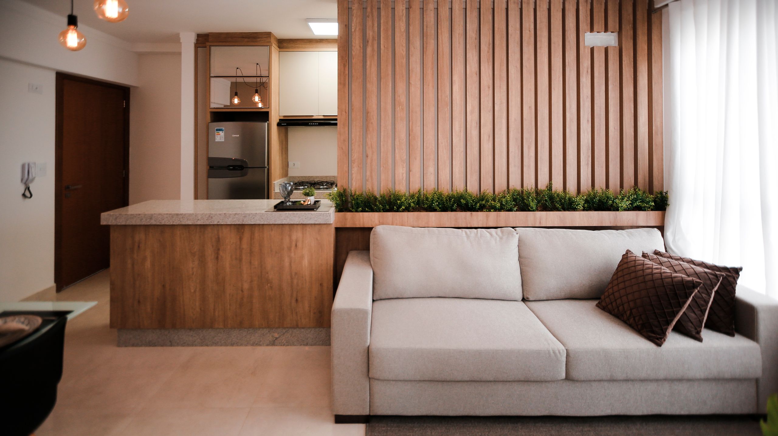Sala de estar elegante con un sofá acogedor y una zona de cocina moderna, perfecta para interiores del hogar.